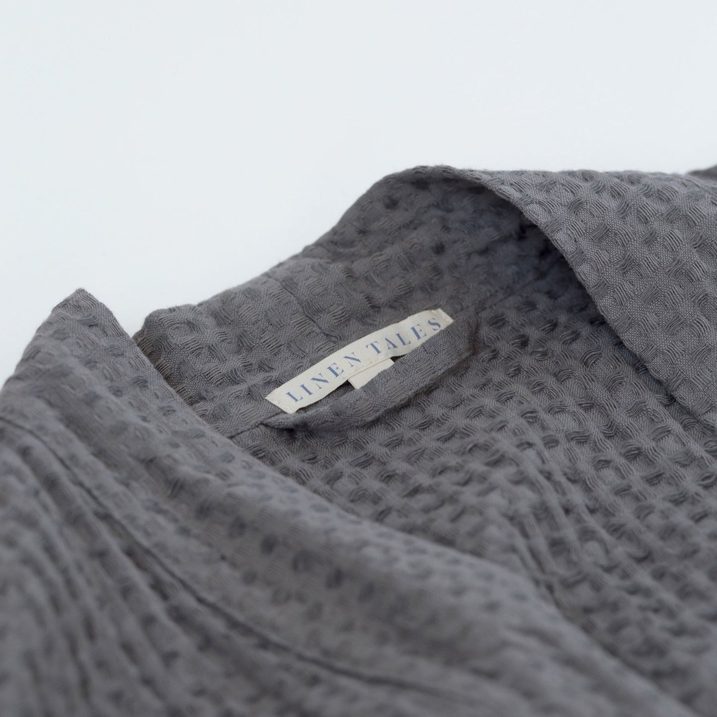 Mörkgrå våffelbadrock i linne, närbild på materialet – Noémie Living