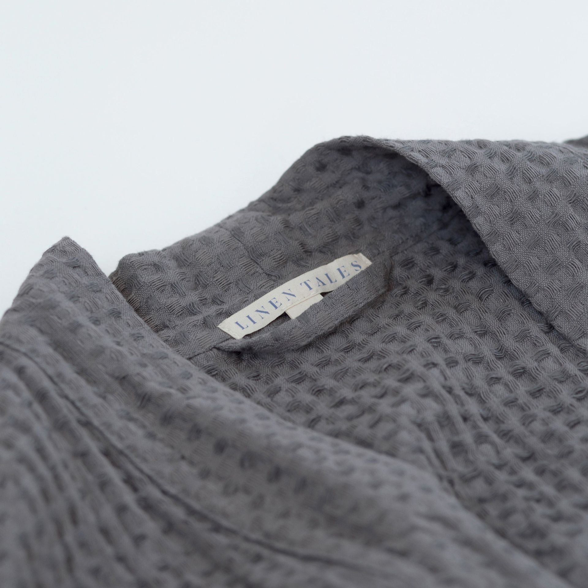 Mörkgrå våffelbadrock i linne, närbild på materialet – Noémie Living