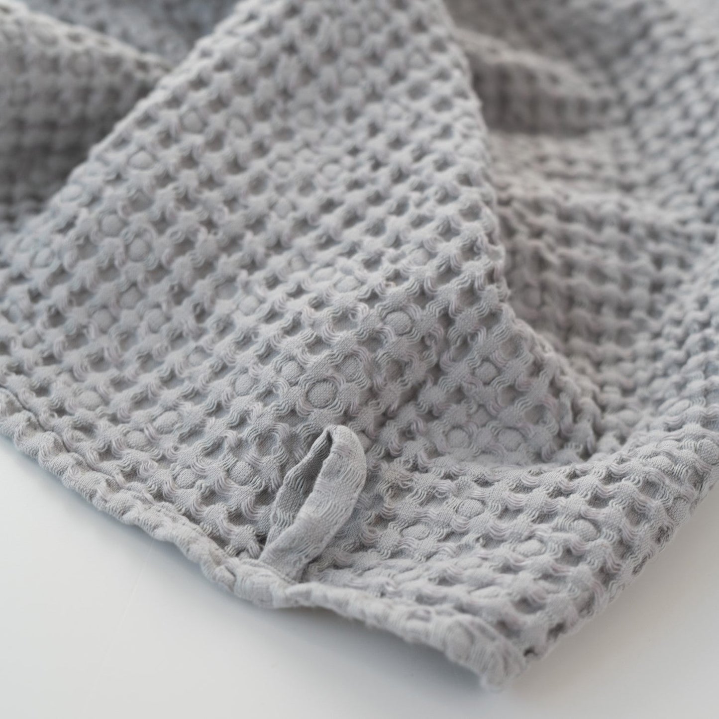 Ljusgrå våffelhandduk i linne, närbild på materialet – Noémie Living